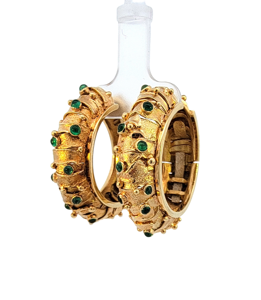 Pair of domed textured closed hoop earrings with round emerald cabochons. Side view