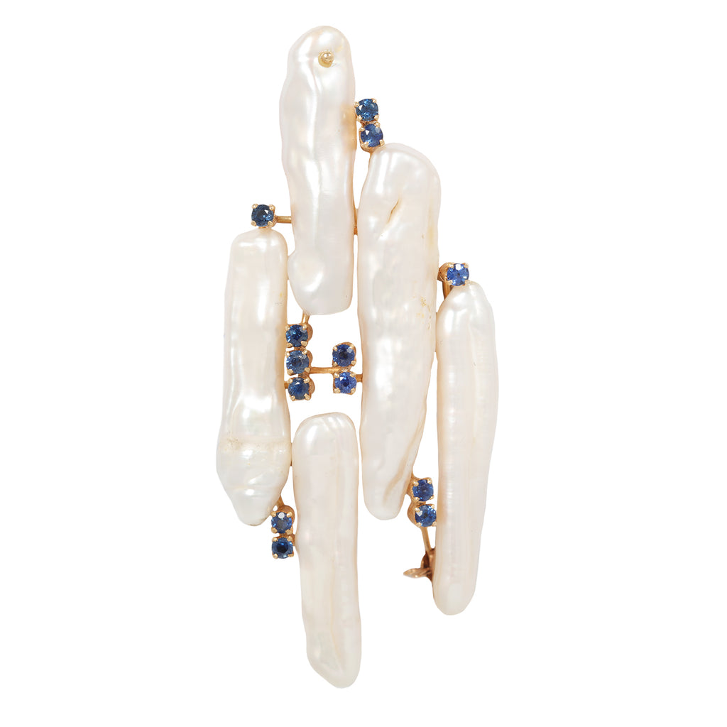 Front view of an abstract brooch featuring long baroque freshwater pearls and blue sapphires set in 18k yellow gold.