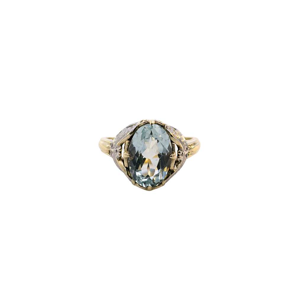 Front view of a light blue oval aquamarine ring framed by white gold butterfly details and a yellow gold band.