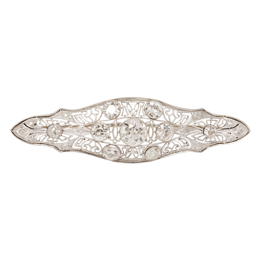 Edwardian navetted-shaped brooch with 9 European-cut bezel  diamonds and delicate openwork.