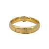 Side view of hinged gold bangle with clasp and safety chain