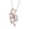 Edwardian platinum and gold diamond bow pendant shown angled, featuring antique old mine–cut diamonds.