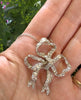 Vintage Edwardian platinum and diamond bow pendant shown on model for scale and neckline appearance.