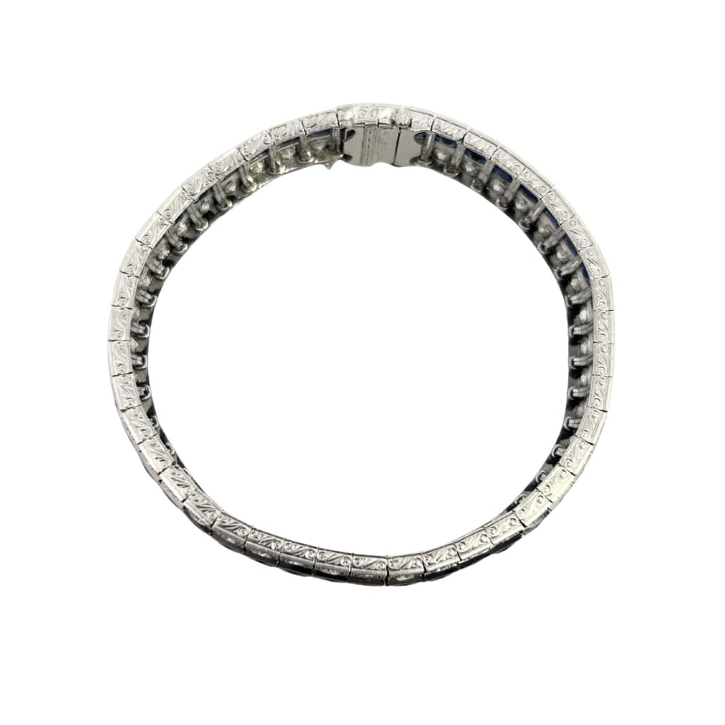 Side profile of engraved platinum bracelet with milgrain detail and flexible links