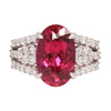 Front view of a platinum ring showcasing a vivid oval rubellite tourmaline framed by brilliant round diamond accents.
