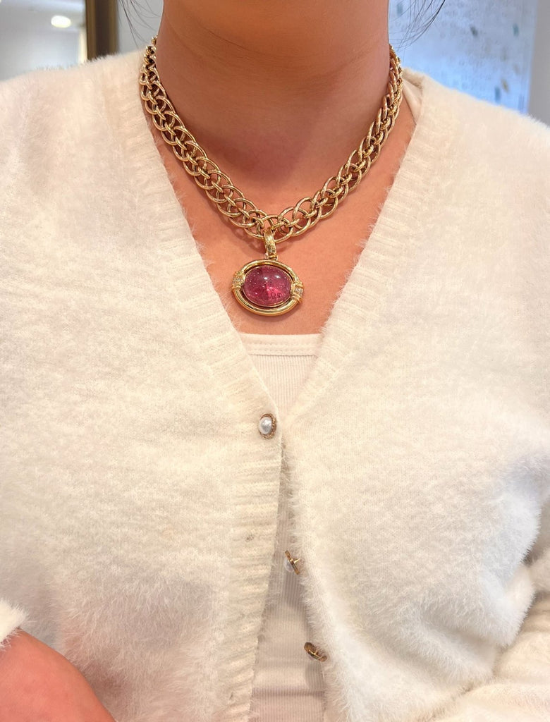 Gump's 18K gold pendant with a pink horizontal tourmaline cabochon, diamond accents, and a hinged bail design. On model.