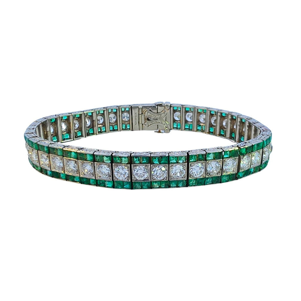 Platinum bracelet with a central row of European-cut diamonds bordered by two rows of square emerald gemstones.