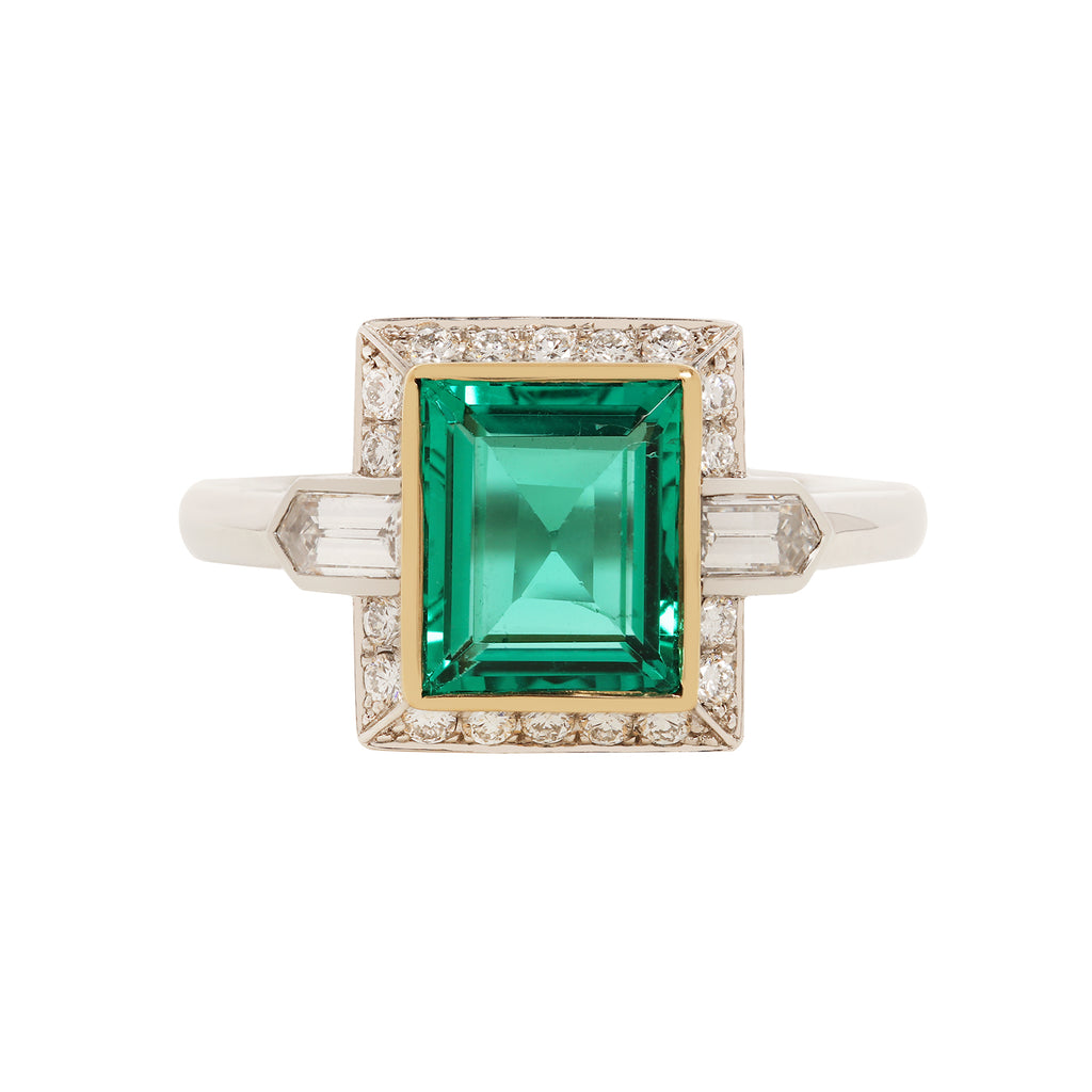 Rectangular Columbian emerald set in yellow gold bezel and framed with diamond.