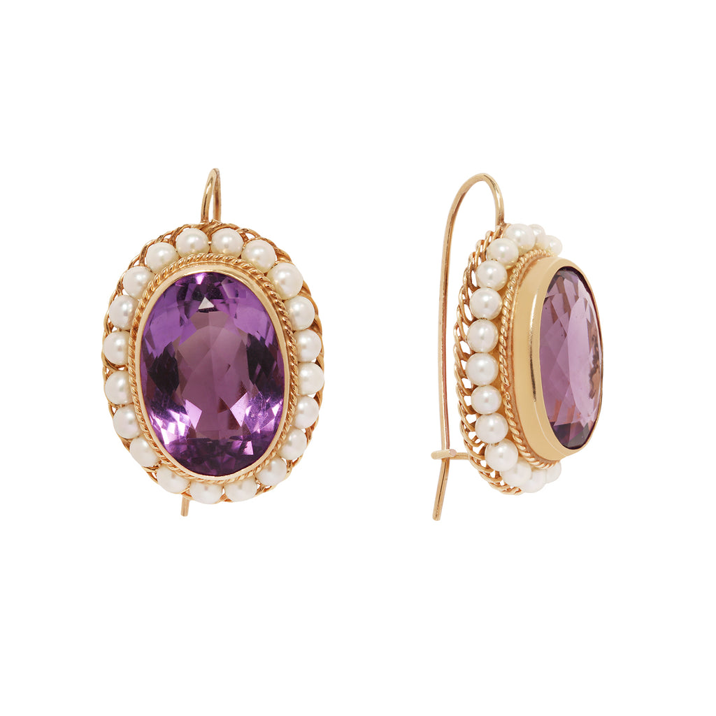 Elegant Victorian 14K gold wire hook earrings with oval amethysts, twisted gold detail, and a pearl frame. Side view.
