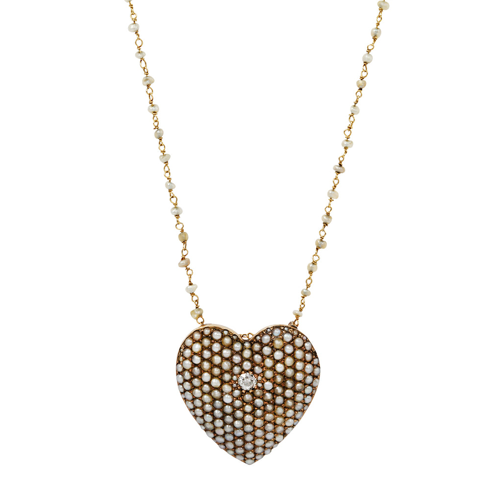 Victorian gold heart necklace. The surface is covered with seed pearls and one European-cut diamond. Worn on a seed pearl chain.