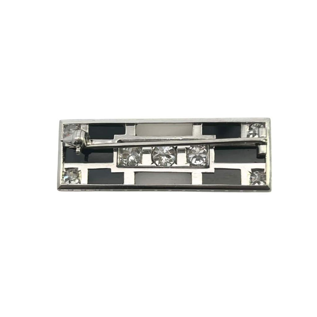 Rectangular Art Deco brooch with white and black onyx panels and seven old European–cut diamonds framed in milgrain, circa 1920s.