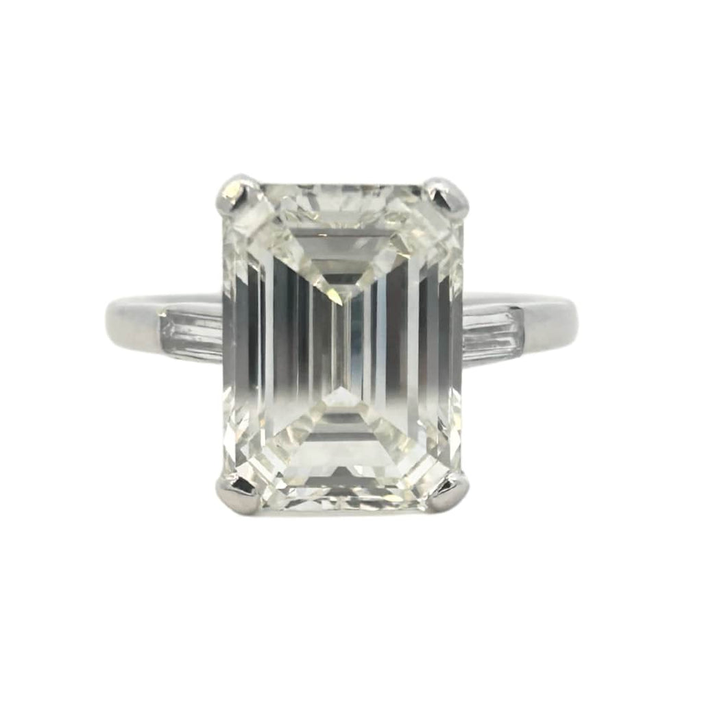 Platinum emerald cut diamond engagement ring featuring a 6.02ct M/VS1 GIA-certified center stone with tapered baguette side diamonds.
