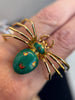 On model view of the enamel spider brooch showing curved gold legs and detailed enamel pattern.