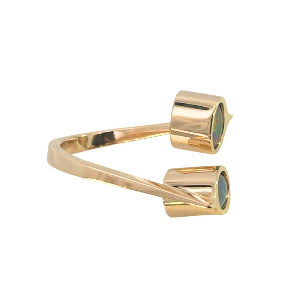 Contemporary 18k yellow gold ring with two oval opal triplets in deep bezels, set at right angles on an open shank.
