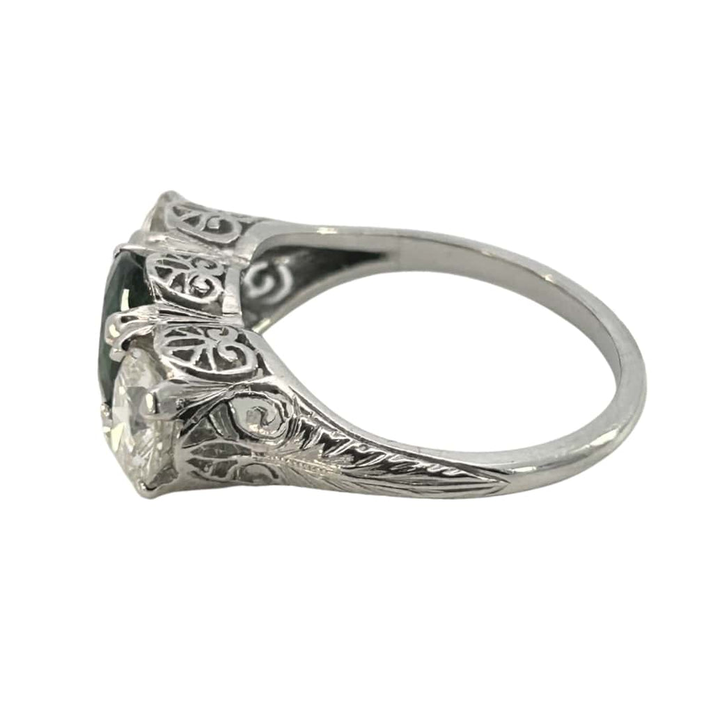 Profile view showing hand-engraved shoulders and pierced filigree basket around the tsavorite.