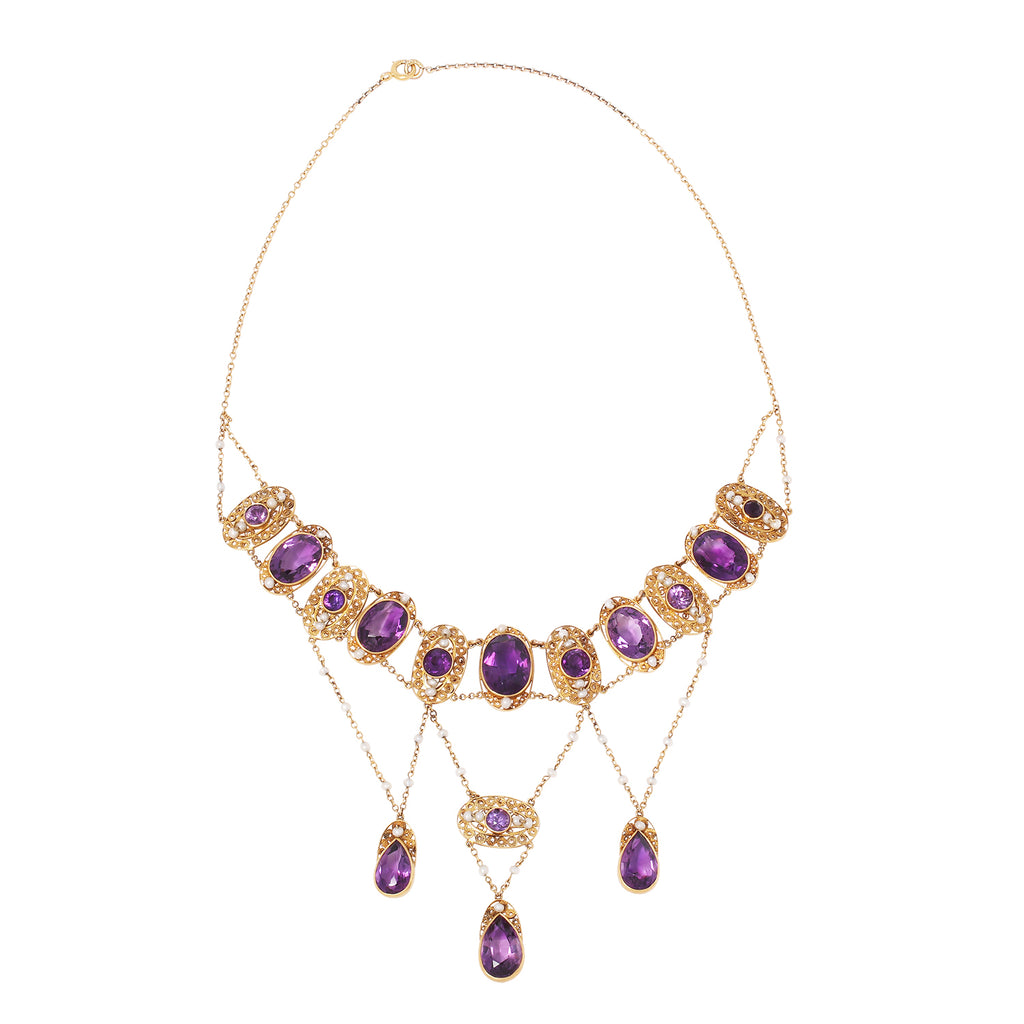 Front view of a Victorian cannetille necklace showcasing bezel-set amethysts and seed pearls in a draped 16” swag design.