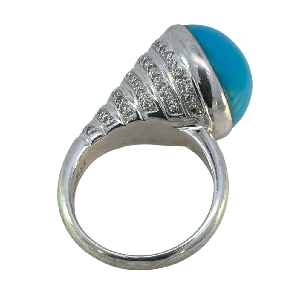 Side view of the turquoise cabochon ring showing sculptural setting and diamond detailing.